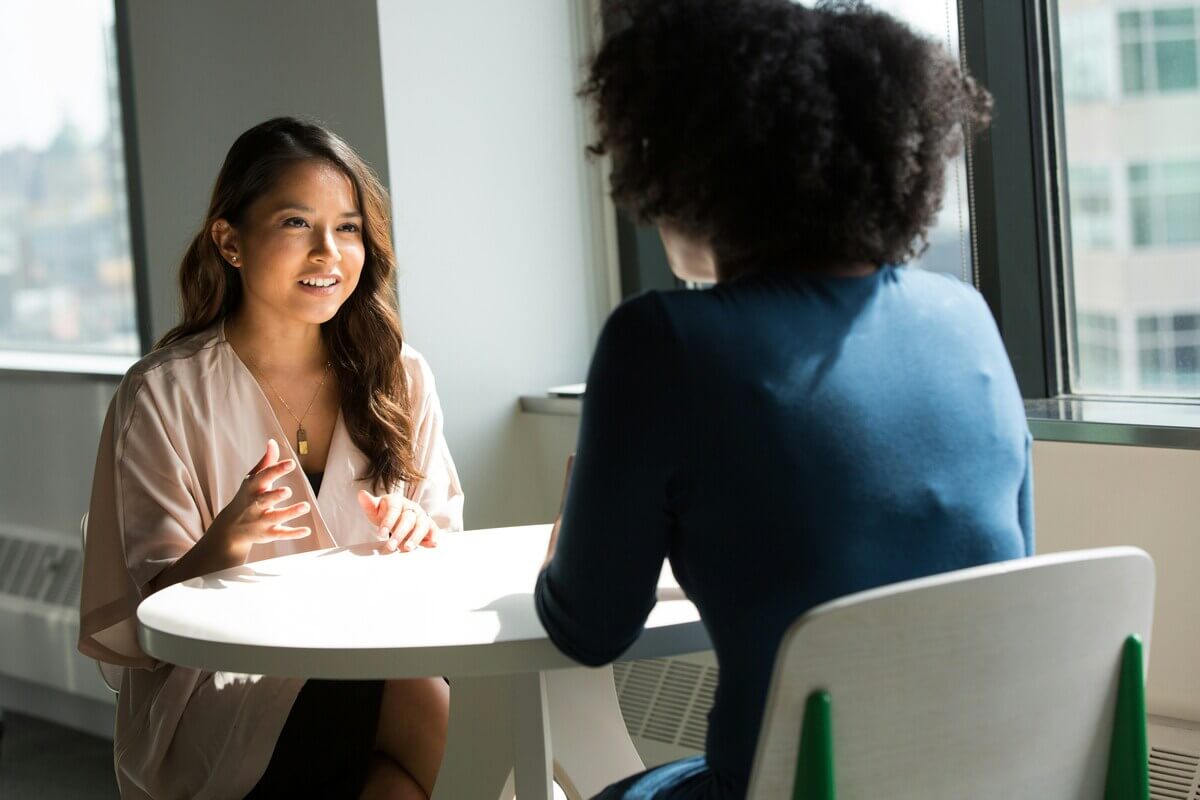 Line manager and team member talking during a feedback meeting