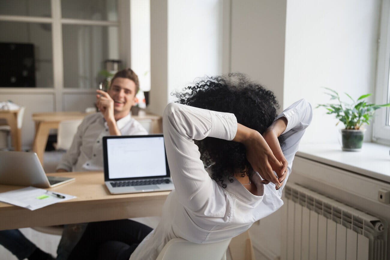 Two colleagues discussing HR issues across their desk at the office