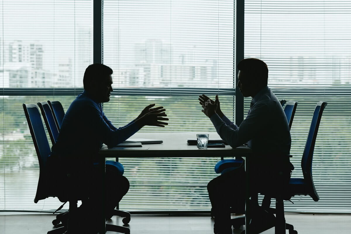 Two men having a conversation about professional development during a 1:1 meeting
