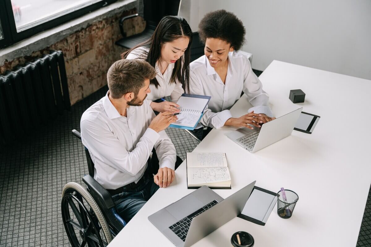 Group of people at work talking about ways to support disabled employees in the workplace